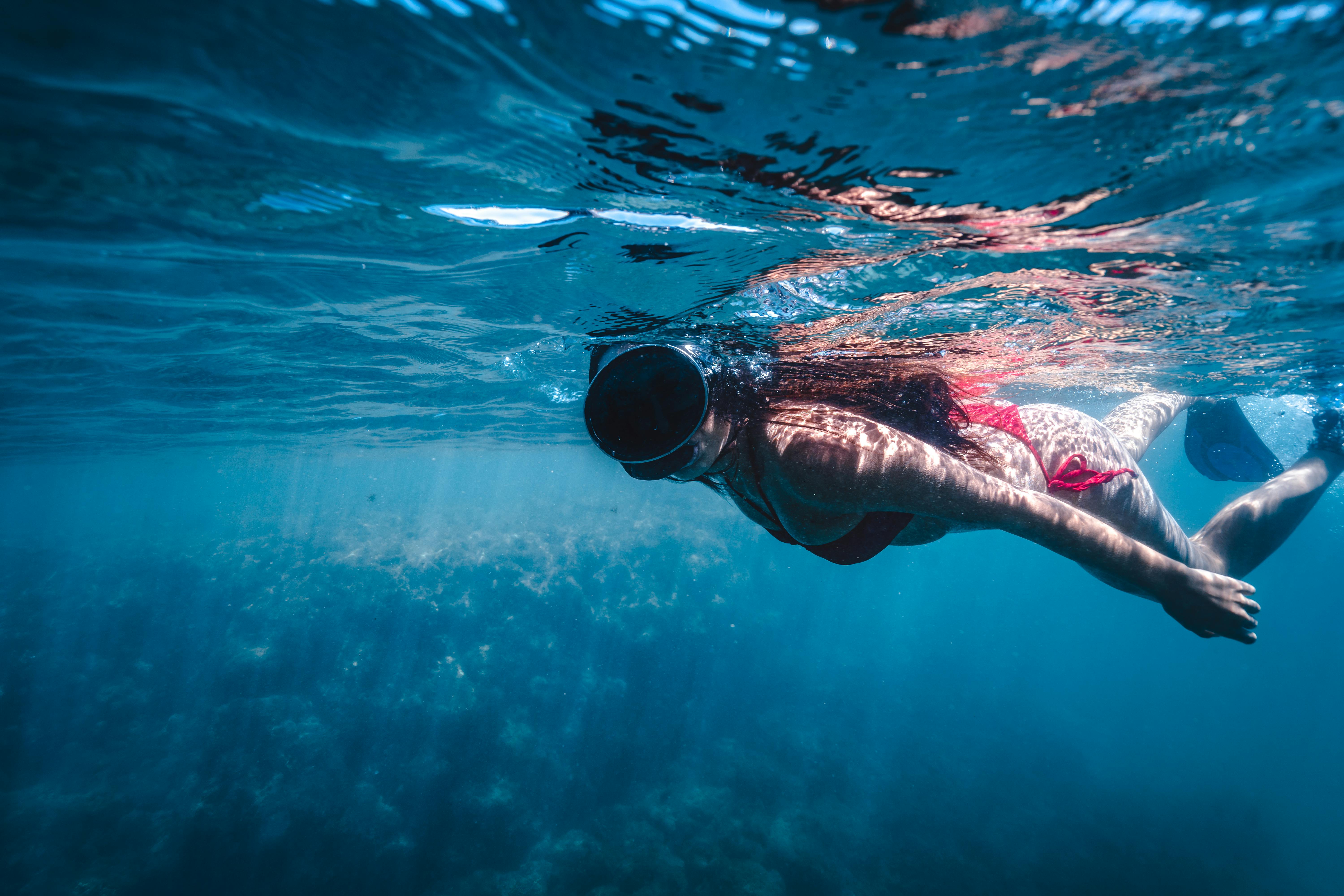 A woman in a scuba diving mask swimming underwater