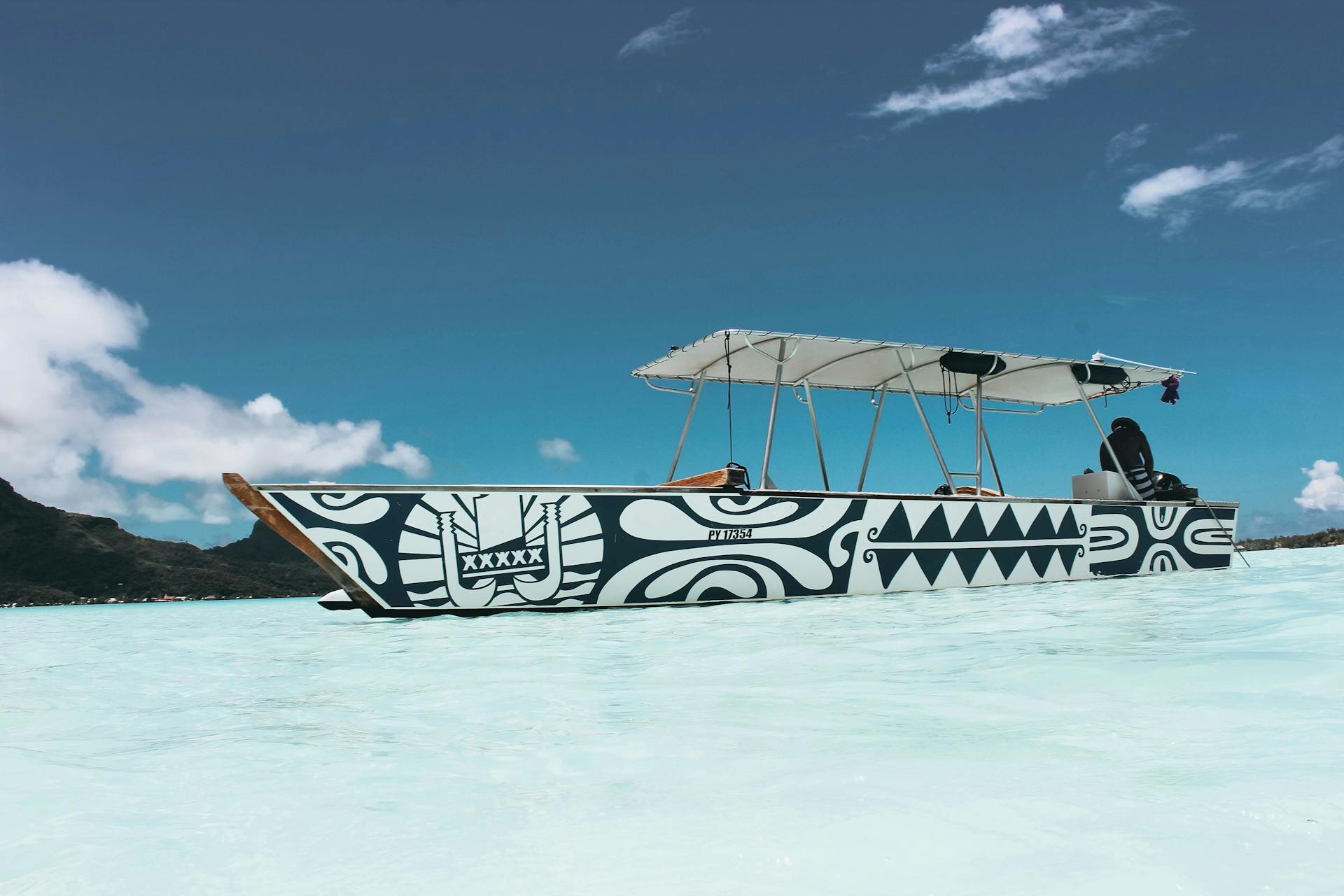 Person sitting on a boat in the sea under a clear sky
